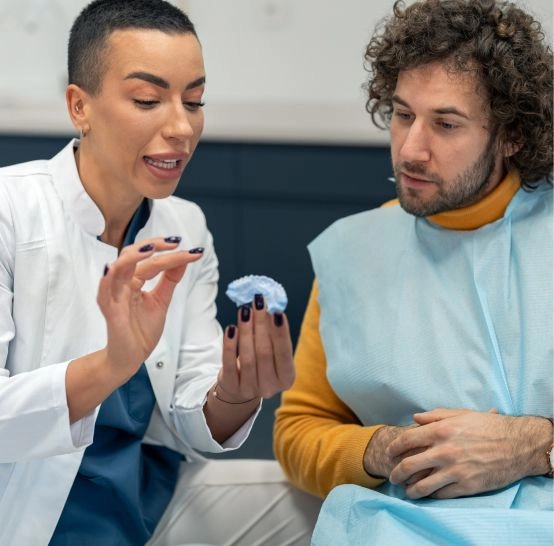 A doctor showing a client a model of teeth